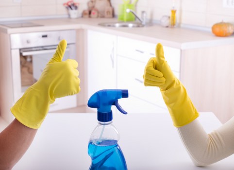 Professional cleaner preparing a fresh short-term rental bedroom